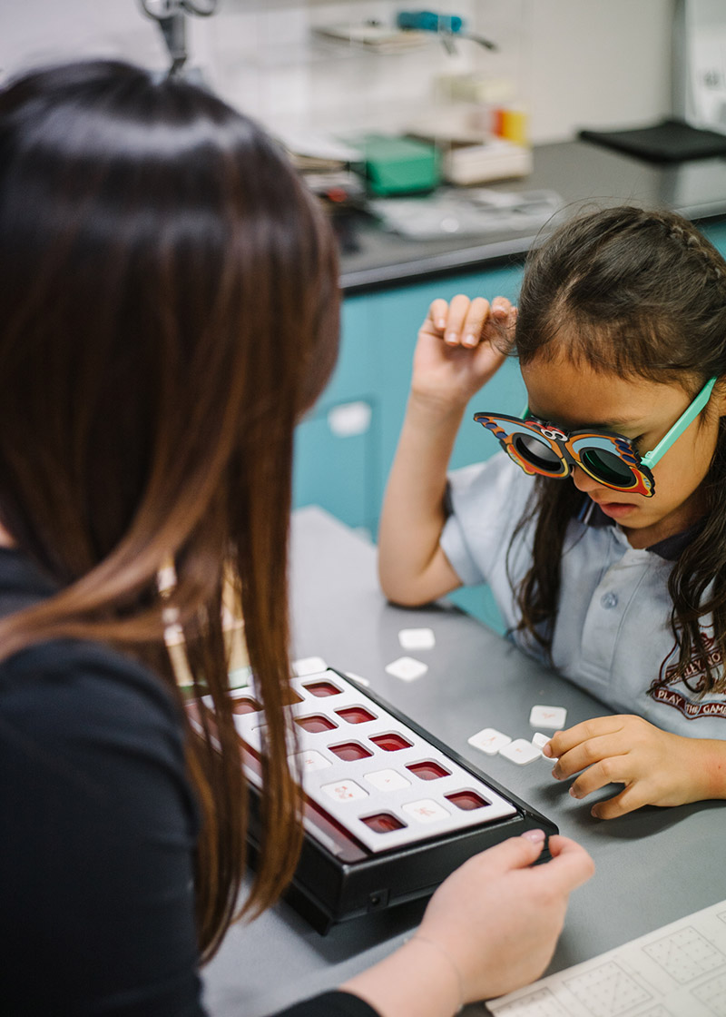 Optometrist gently examining an infant's eyes